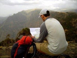 Trauma checks map and compass heading as he hikes across Africa.