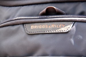 Briggs & Riley logo on leather tab atop front pocket.